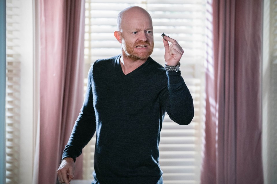 Max Branning from EastEnders holding a small object.