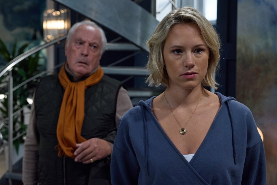 A woman listens intently as an older man stands behind her.