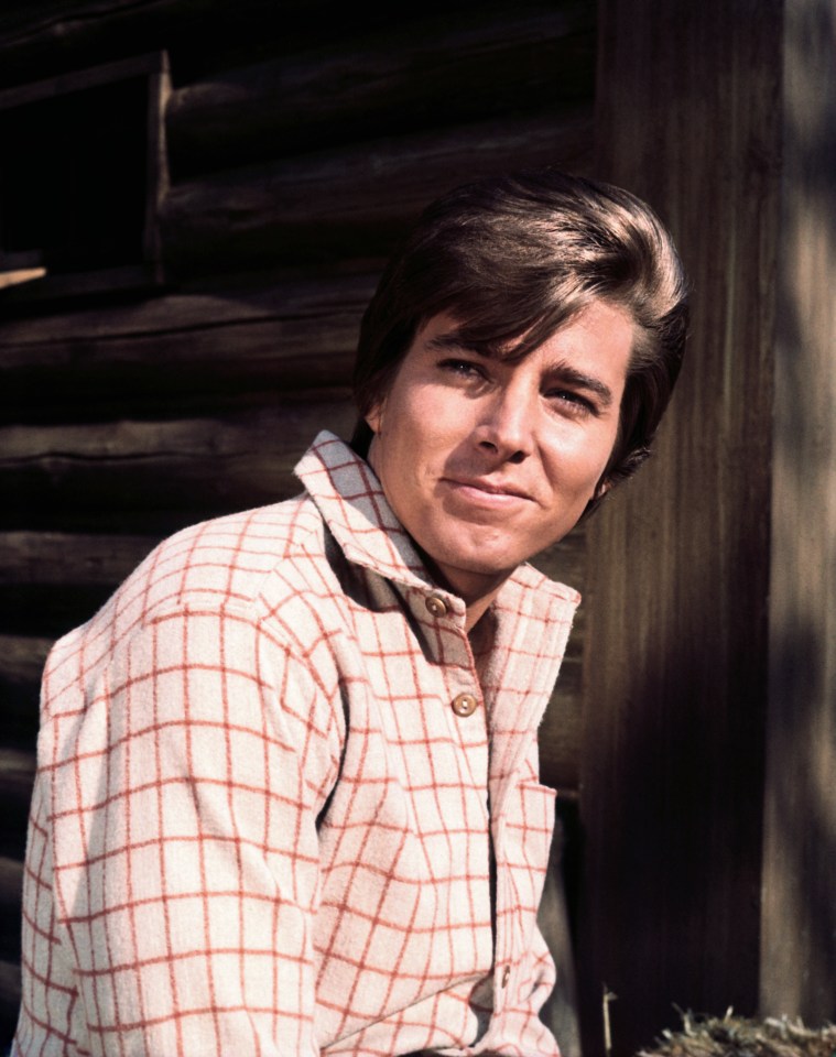 Portrait of a young man in a red and white plaid shirt.