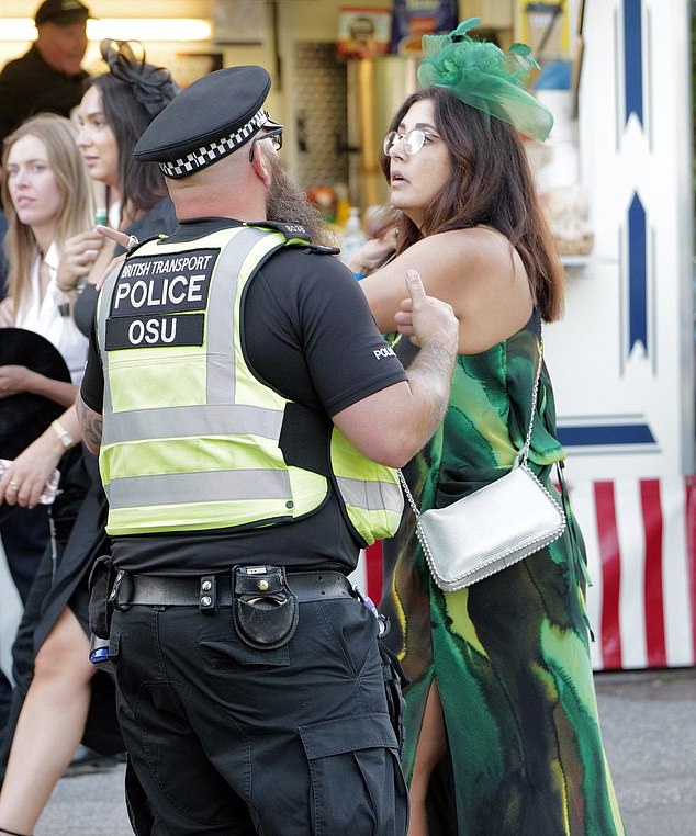 DAY ONE: Woman donning a green summer dress being seen handled by a police officer