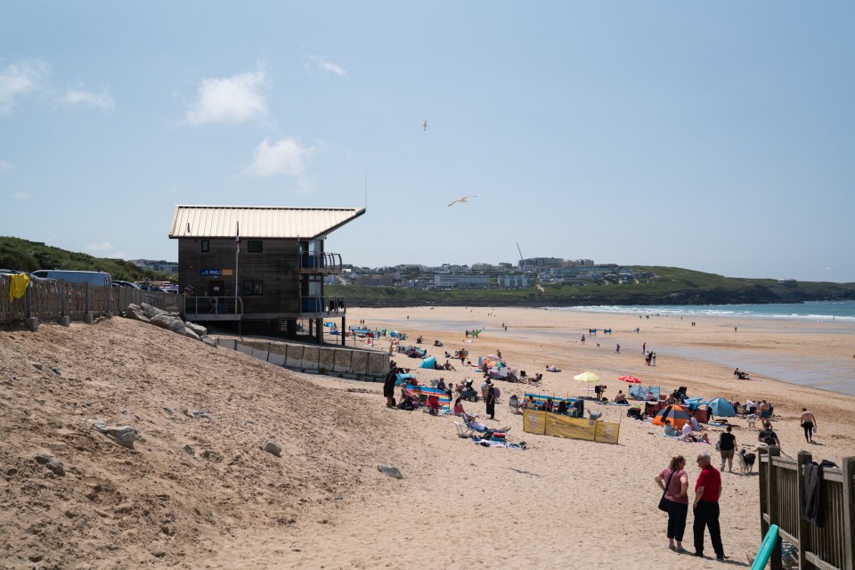 Crowded Fistral Beach in Newquay, Cornwall with a lifeguard station.