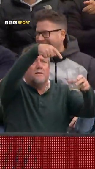 Two men in the audience making gestures.