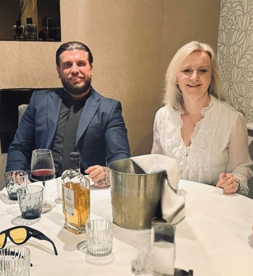 Man and woman sitting at a table with drinks and glasses.