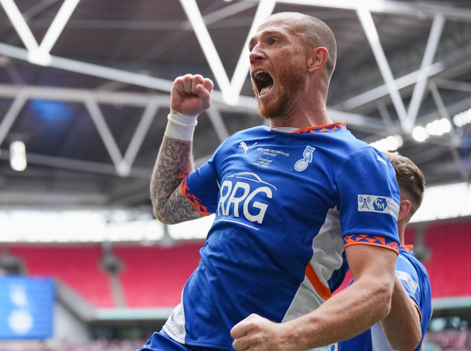 A soccer player celebrates a goal at Wembley Stadium.