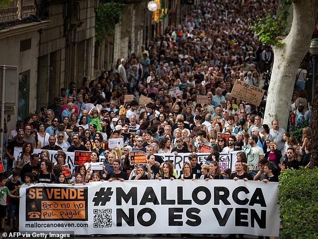 Protesters hold a banner reading "Mallorca is not for sale" during a demonstration to protest against the massification of tourism and housing prices on the island of Mallorca in Palma de Mallorca on May 25, 2024
