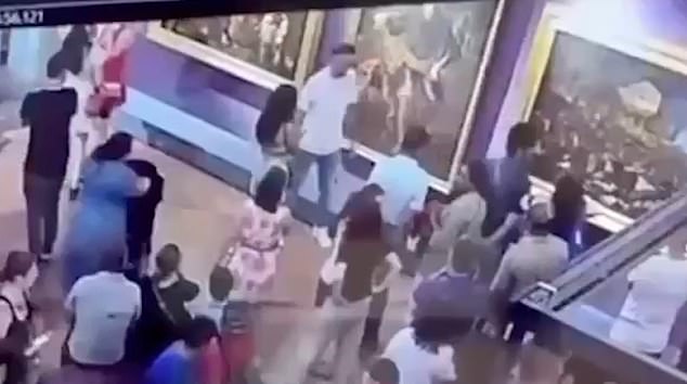A careless tourist left a museum director furious after he damaged a valuable painting while trying to take a selfie