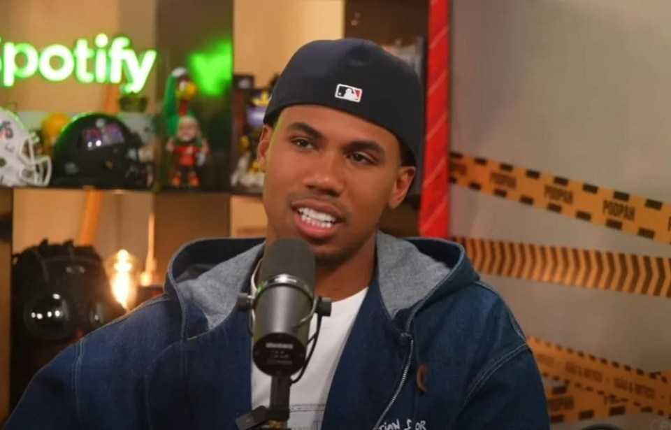 Man in a denim jacket speaking into a microphone.