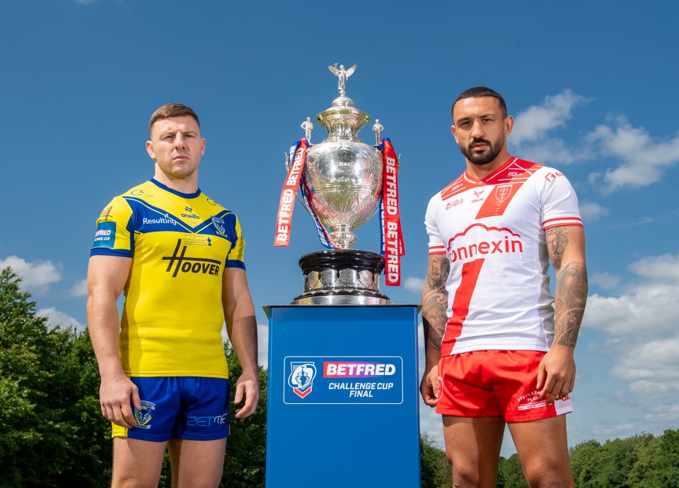 Two rugby players standing on either side of the Betfred Challenge Cup.