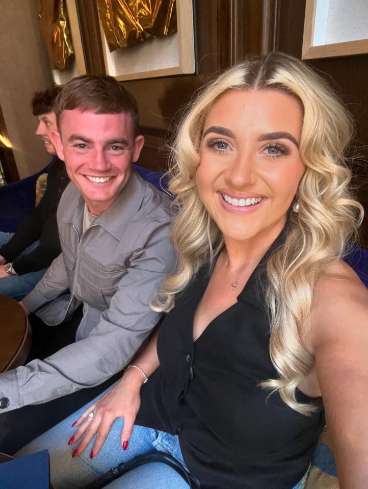 Izzi Warner and a man smiling for a photo.
