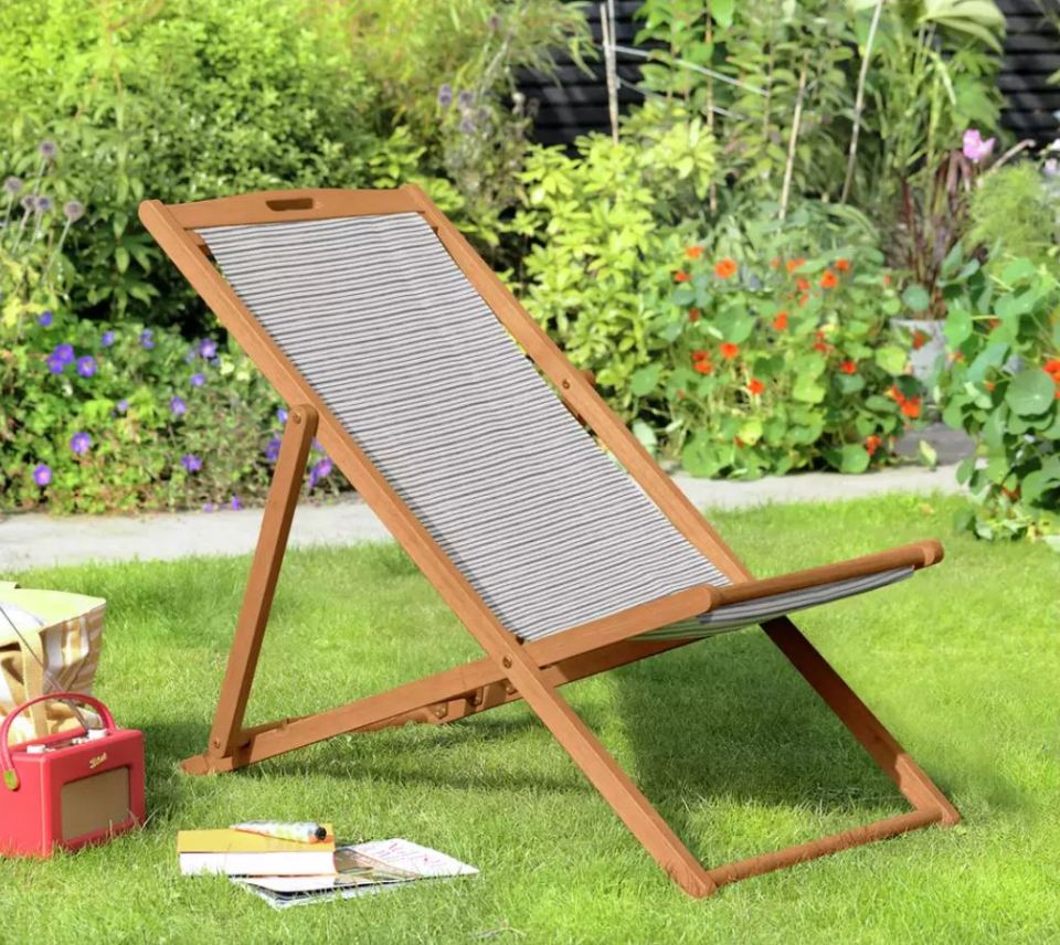 Wooden folding deck chair on a lawn.