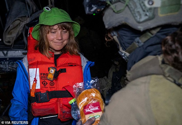 The climate campaigner-turned-Palestine freedom fighter, safe in an orange life jacket and a green frog-shaped sun hat, gazing at the Israeli sandwich with a hungry smile