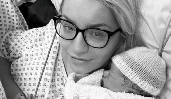 Black and white photo of a mother holding her newborn baby in the hospital.