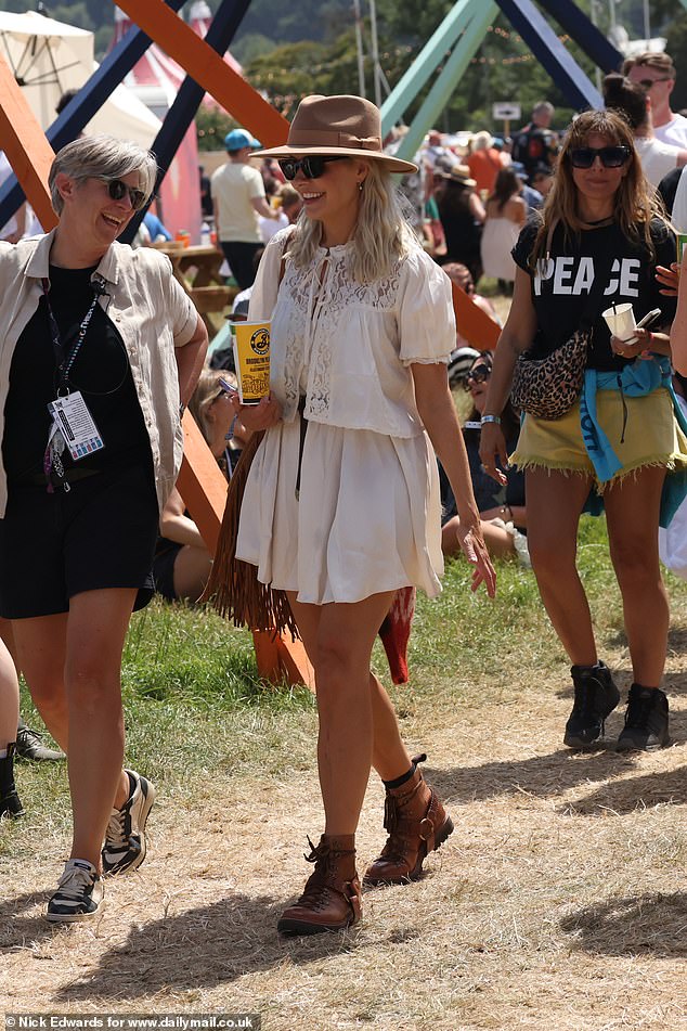 Holly Willoughby got into the festival spirit as she milled around Glastonbury with a drink in hand on Friday