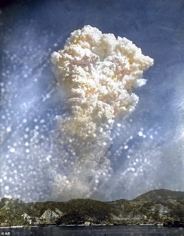 A digitally colorized image shows smoke rising 20,000 above the city after the bomb was dropped