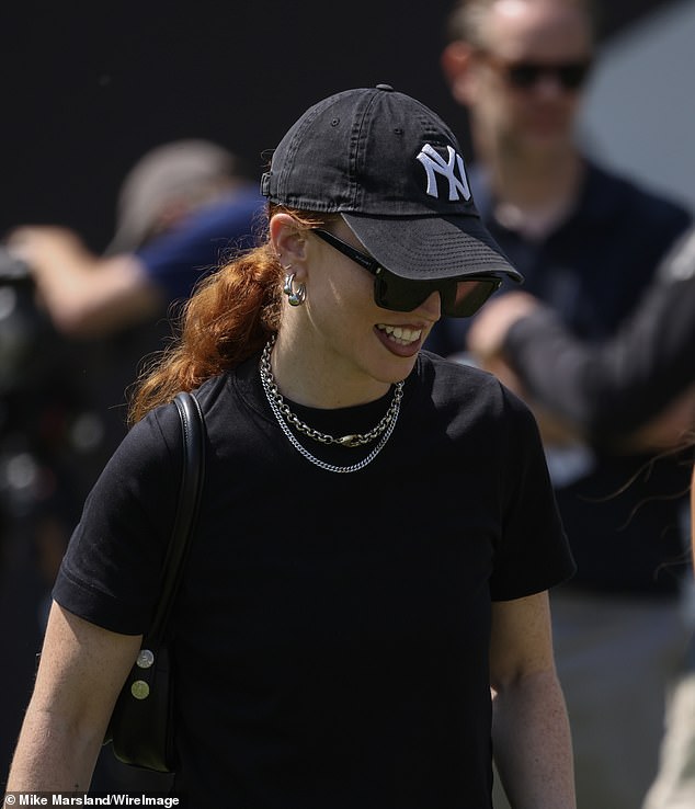 The pop star sports a black cap and t-shirt and accessorises with silver jewellery as she attended the event