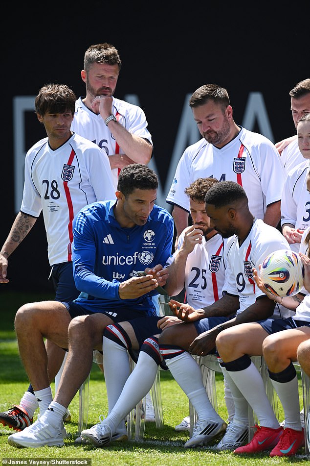 Louis Tomlinson (left) appeared to give Sam Thompson (seated in centre) a 'hard stare' as the two men met during an awkward training session for Soccer Aid 2025 on Friday - moments before Sam revealed he would not be playing in Sunday's match on doctor's orders