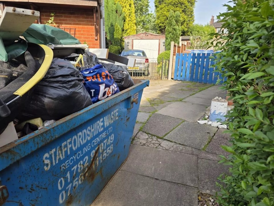 Skip overflowing with rubbish in a residential driveway.