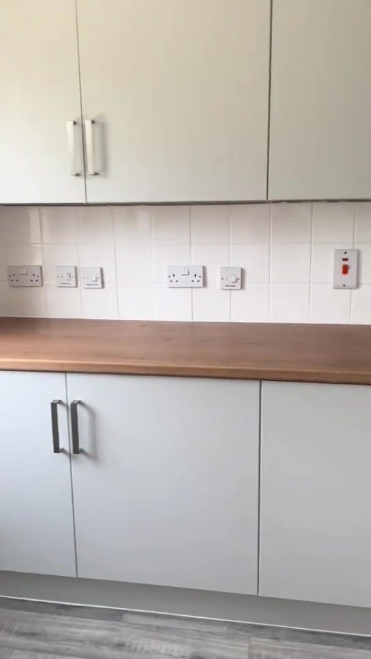 DIY kitchen makeover with light grey cabinets and wood countertop.