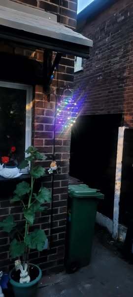 Multicolored string lights hanging outside a house.