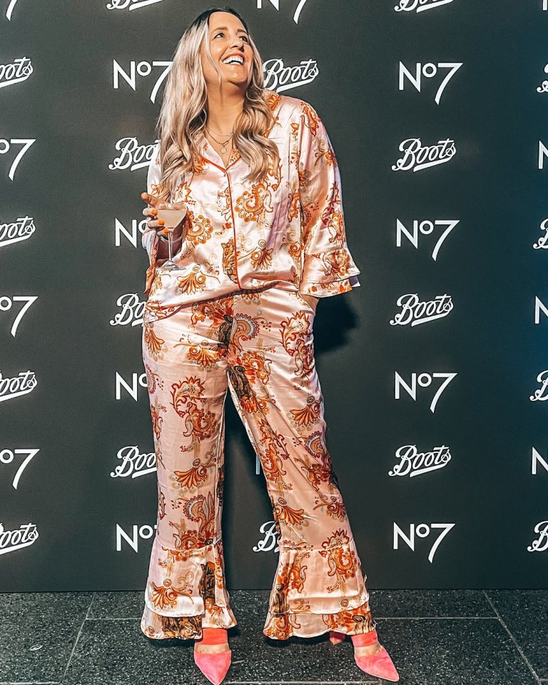 Woman in patterned pajamas holding a drink at a Boots event.