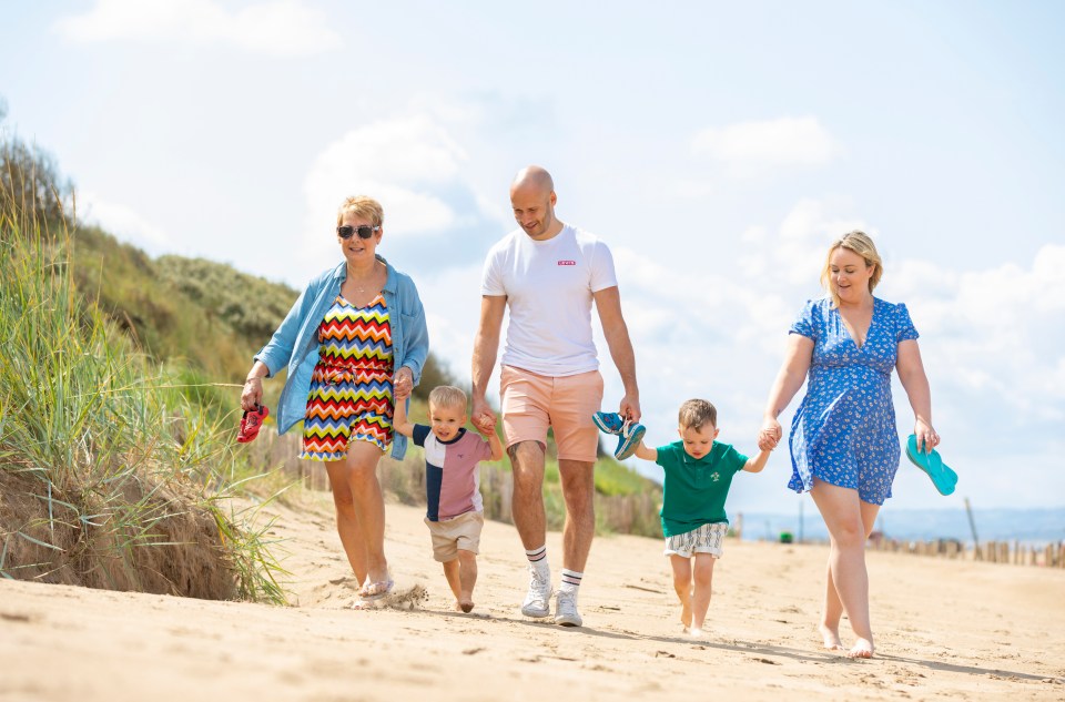 Family walking on a sandy beach.