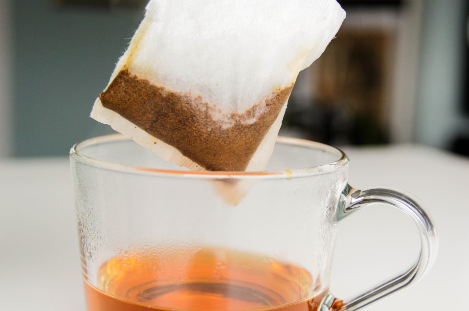 Tea bag being removed from a cup of tea.