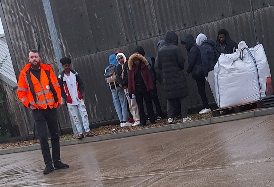 A security guard and a group of detained immigrants at a distribution center.