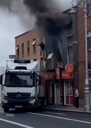This is the heartstopping moment a hero lorry driver reversed his truck near a burning building to save a man.