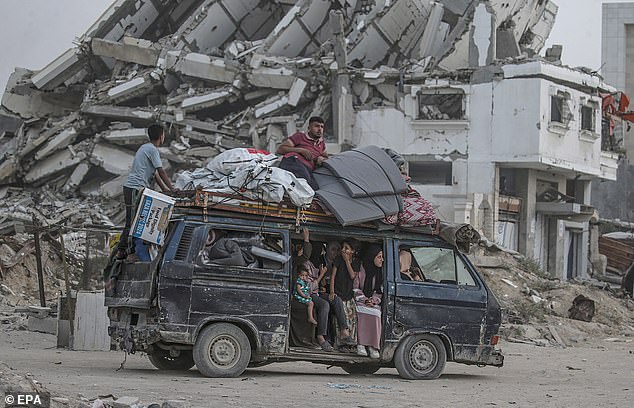 'This is a final and urgent warning ahead of an impending strike,' army spokesman Avichay Adraee said. The army 'will strike all areas from which rockets are launched,' he added. Pictured: Displaced Palestinians leave with their belongings following an evacuation order issued on Monday, May 19