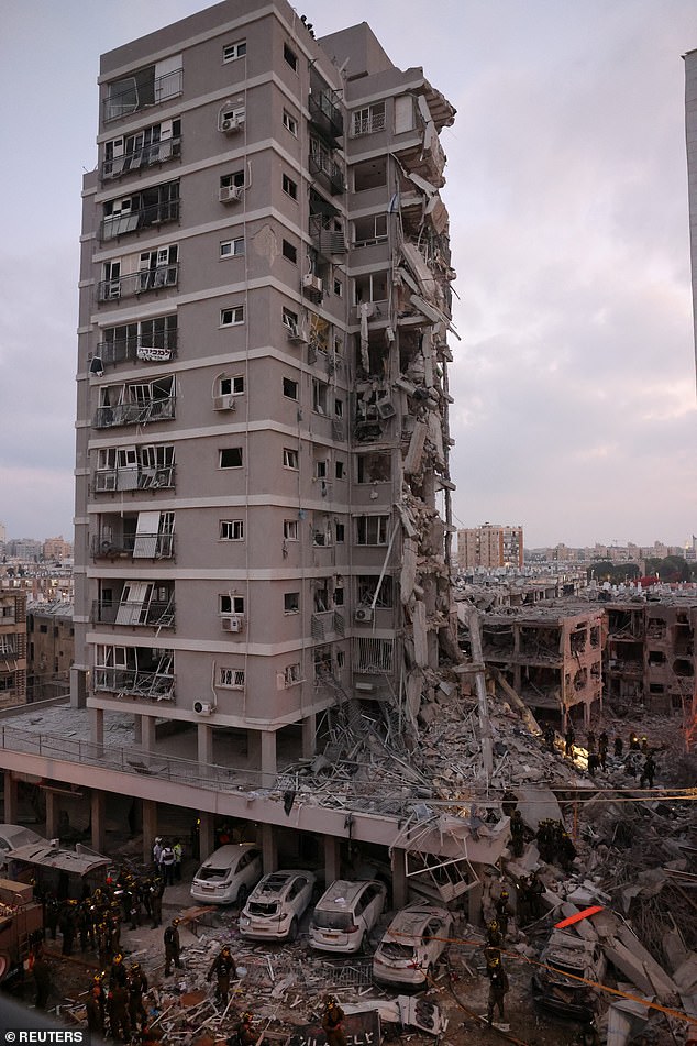 People stand near a residential building that was hit following missile attack from Iran on Israel, at central Israel June 15, 2025