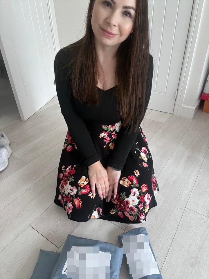 Woman in floral skirt sitting on the floor with packages.