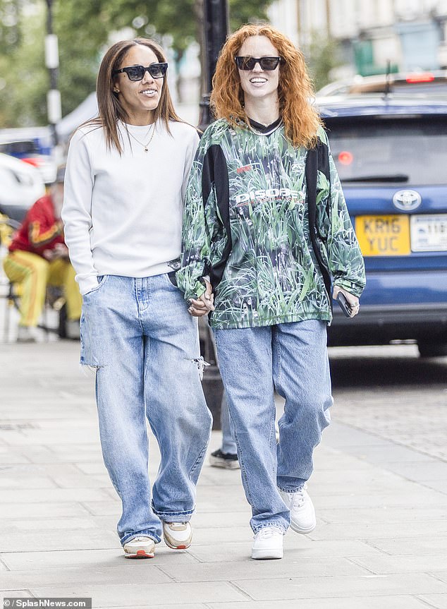 Jess Glynne (right) and Alex Scott (left) look happier than ever as they took a stroll hand-in-hand around London on Saturday