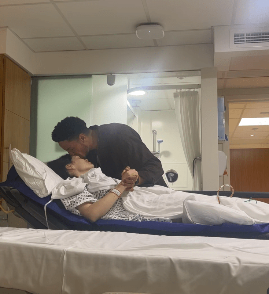 Man kissing woman in hospital bed.