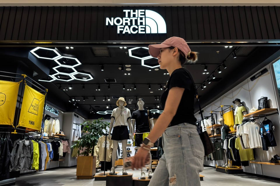 Woman walking past a North Face store.