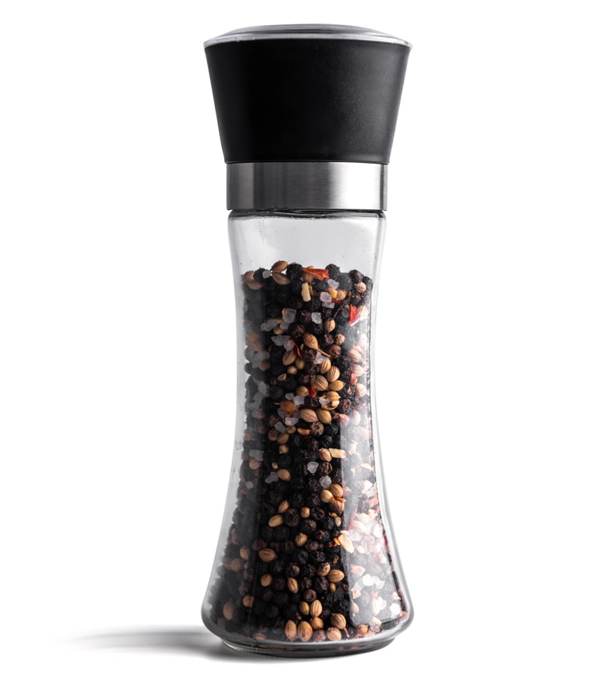 Glass grinder filled with pepper and salt blend.