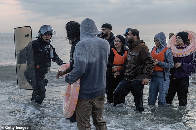 It comes after The Mail on Sunday revealed how little the French authorities are doing to prevent dinghies setting sail. Pictured: French Police enter the water to try to stop migrants boarding small boats at Gravelines, France, on June 13