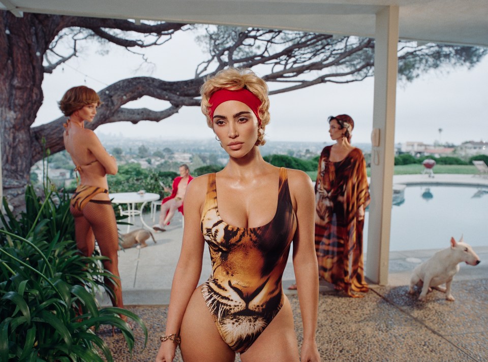 Woman in tiger-print swimsuit with other women in background.