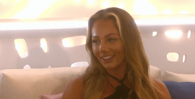 Screenshot of a woman with long blonde hair smiling.