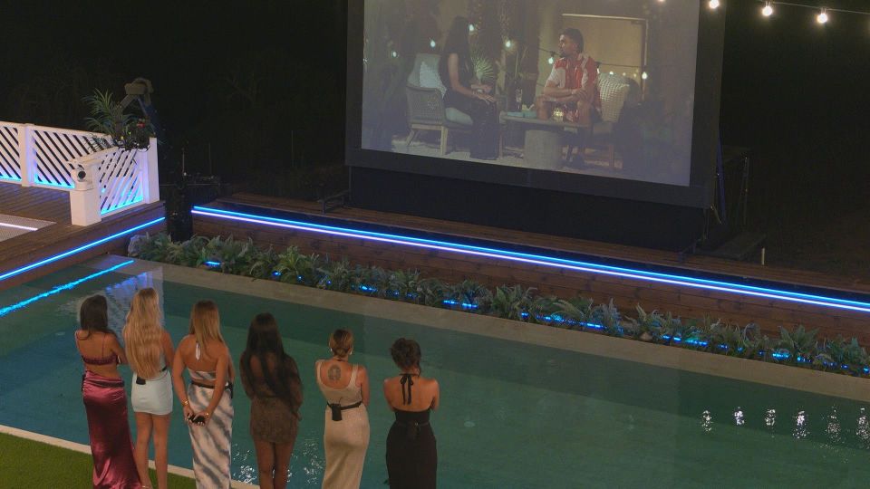Women watching a video by the pool.