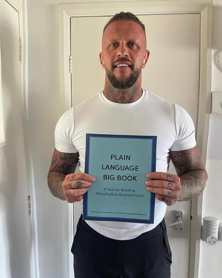 Man holding the Alcoholics Anonymous Plain Language Big Book.