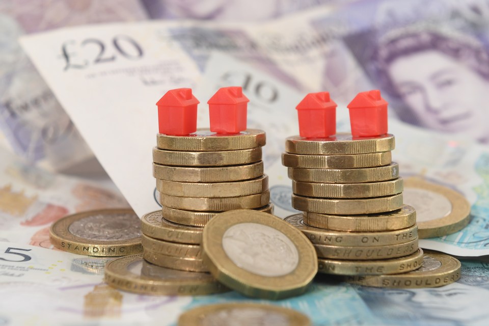 Model houses atop stacks of coins on British banknotes.