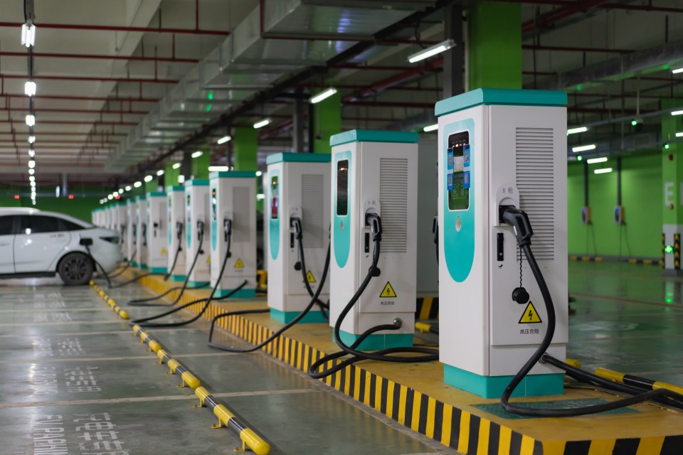 Row of electric vehicle charging stations in a parking garage.