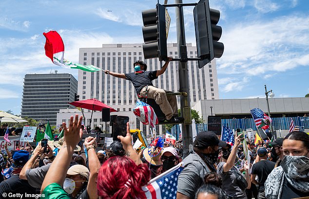 Pictured: Anti-Trump protestors confront US Marines and National Guardsmen on Saturday, the same day President Trump's birthday military parade is taking place