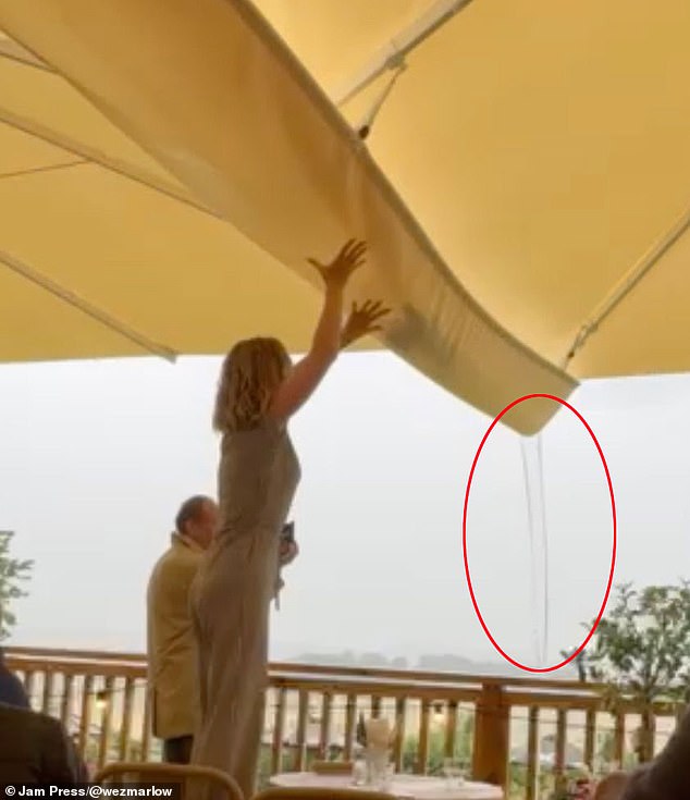 This is the moment water collected in Jeremy Clarkson 's controversial £40,000 gazebo soaked the decking at The Farmer's Dog pub