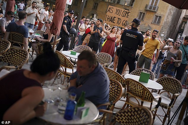 Police officers in Majorca had to form a protective shield in front of holidaymakers dining in a restaurant as crowds of anti-tourist protestors gathered during a mass demonstration on Sunday afternoon