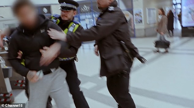 A passenger pushes through the gates at Kingston station in South West London without touching out before attacking British Transport Police officers while they try to apprehend him
