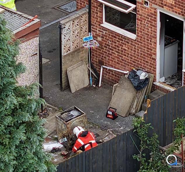 Two firefighters have also been seen inspecting what appears to be a washing machine in the house's back garden