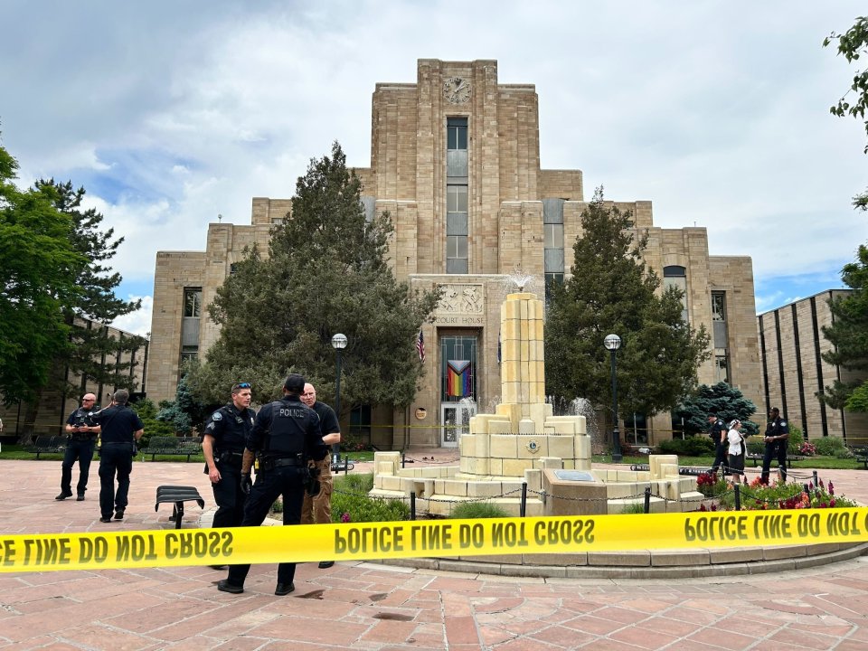 Police officers investigating a scene in front of a courthouse.