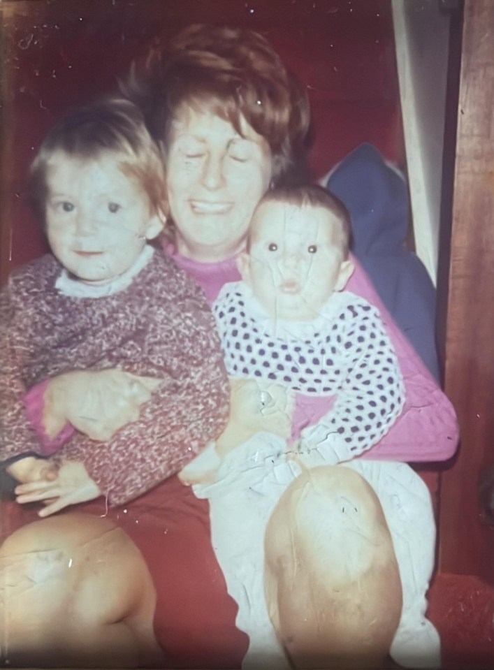 Photo of a woman holding two young children.