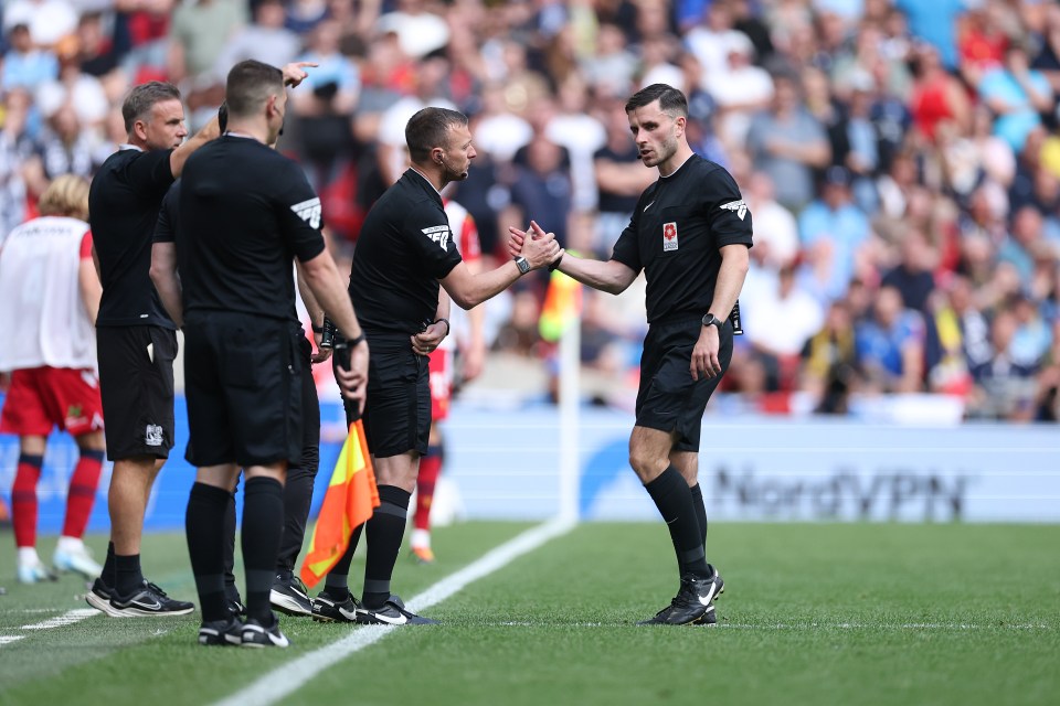 A soccer referee is being substituted for the fourth official.